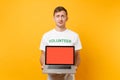 Man in white t-shirt written inscription green title volunteer hold laptop pc computer with blank empty screen isolated Royalty Free Stock Photo
