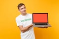 Man in white t-shirt written inscription green title volunteer hold laptop pc computer with blank empty screen isolated Royalty Free Stock Photo