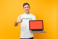 Man in white t-shirt written inscription green title volunteer hold laptop pc computer with blank empty screen isolated Royalty Free Stock Photo