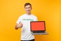 Man in white t-shirt written inscription green title volunteer hold laptop pc computer with blank empty screen isolated Royalty Free Stock Photo