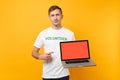 Man in white t-shirt written inscription green title volunteer hold laptop pc computer with blank empty screen isolated Royalty Free Stock Photo