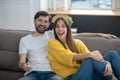 Man in white tshirt and girl in yellow sweater on sofa Royalty Free Stock Photo