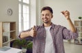 Happy man showing keys to his new house or apartment , smiling and giving thumbs up Royalty Free Stock Photo