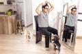 Man who is cutting his hair himself in front of a mirror in his living room with his dogs accompanying him