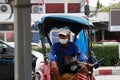 The man who rides the tricycle hire wearing hygienic mask sitting and waiting for passengers in his own tricycle Royalty Free Stock Photo