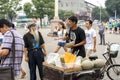 A man who sell hami melon with an old man in communication, in the streets of Beijing