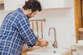 Man widower doing chores or house work alone cleaning wash dishes in the kitchen during stay home Royalty Free Stock Photo