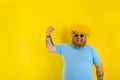 Fat man with wig in head and sunglasses shows his muscle Royalty Free Stock Photo