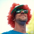 Man, wig and sunglasses with nature, sky and festival for fun, joy and celebration. Person, summer and concert with low Royalty Free Stock Photo