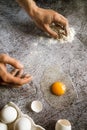 Man will prepare dough in the kitchen from flour and fresh white farm eggs on a gray neutral background 1 Royalty Free Stock Photo