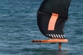 A man is wing foiling using handheld inflatable wings and hydrofoil surfboards Royalty Free Stock Photo