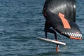 A man is wing foiling using handheld inflatable wings and hydrofoil surfboards