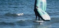 A man is wing foiling using handheld inflatable wings and hydrofoil surfboards in a blue ocean Royalty Free Stock Photo