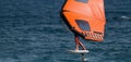 A man is wing foiling using handheld inflatable wings and hydrofoil surfboards