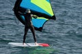 A man is wing foiling using handheld inflatable wings and hydrofoil surfboards Royalty Free Stock Photo