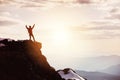 Man in winner pose at mountain top against mountains and sunset Royalty Free Stock Photo