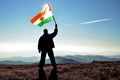 Man winner waving Niger flag on top of the mountain peak