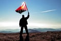 man winner waving Papua New Guinea flag on top of the mountain peak