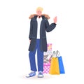 Man in winter clothes standing near purchases new year christmas shopping seasonal sale concept Royalty Free Stock Photo