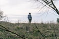 Man in winter jacket standing alone at the edge of a field - loneliness or existential void concept