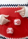 Man in winter sweater holding Christmas balls in hands. Close up Royalty Free Stock Photo