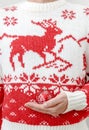 Man in winter sweater holding Christmas balls in hands. Close up Royalty Free Stock Photo