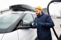 Man wipes american SUV car mirror with a microfiber cloth after washing in cold weather Royalty Free Stock Photo