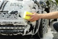 Man wipes the car with sponge. Car wash. Clear car concept