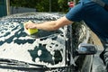 Man wipes the car with sponge. Car wash. Clear car concept