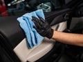 A man wipes the surface of the car interior with a microfiber cloth. Royalty Free Stock Photo