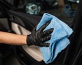 A man wipes the surface of the car interior with a microfiber cloth. Royalty Free Stock Photo