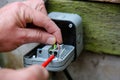 Man wiring an electric socket using an electrical screwdriver