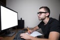 Man woking at PC on white screen monitor and make notice Royalty Free Stock Photo