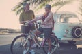Man and woman adult elderly activity with an old bicycle. Vintage beautiful old van in the background. Sunlight in backlight for