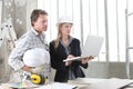 Man and woman architect interior designer and foreman worker together with computer and decorative materials discussing the