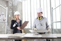 Man and woman architect interior designer and foreman worker together with tiles samples and decorative materials discussing the Royalty Free Stock Photo