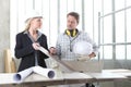 Man and woman architect interior designer and foreman worker together with tiles samples and decorative materials discussing the Royalty Free Stock Photo