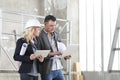 Man and woman architects or engineers with computer work together in the inside the construction building site Royalty Free Stock Photo