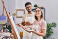 Man and woman artists drinking coffee drawing at art studio