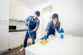 Man and woman as a professional cleaners in the kitchen