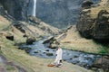 Man and woman in a blanket stand on the banks of a river in the mountains. Iceland Royalty Free Stock Photo