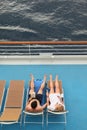 Man and woman both relaxing on chaise longues