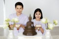 Man and woman Buddhist in white dress sitting  in front of set of altar table and paying homage to buddha image. Idea for ritual Royalty Free Stock Photo