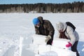 Man and woman building an igloo in snowy glade, Novosibirsk, Russia