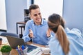 Man and woman business workers speaking and working at office