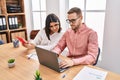 Man and woman business workers using laptop and touchpad working at office Royalty Free Stock Photo