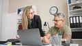 Man and woman business workers working together using laptop at the office Royalty Free Stock Photo