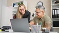 Man and woman business workers working together using laptop at the office Royalty Free Stock Photo