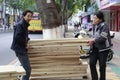 Man and woman carry plank of wood