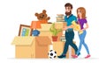 Man and woman carrying books and vase near pile of cardboard boxes, picture, plant, ball, teddy bear, table lamp. Royalty Free Stock Photo